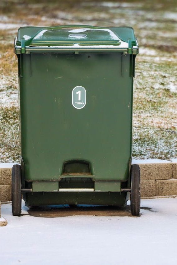 Two green garbage bins on a snowy day in Jönköping, Sweden.