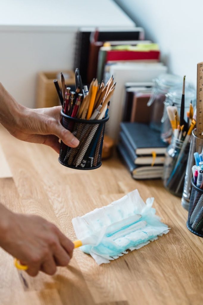 A clean, organized desk with stationery and dusting supplies for efficient workspace.